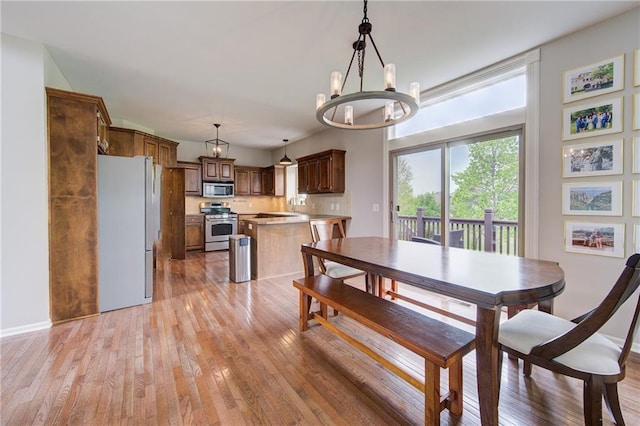 8812 NE 101st St, Kansas City, MO 64157 - dining room featuring a chandelier, light wood-type flooring, and baseboards