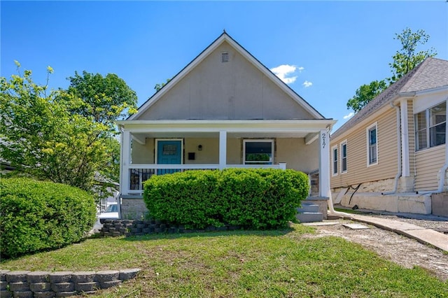 217 N Valley St, Kansas City, KS 66102 - view of front of property with a front yard, a porch, and stucco siding