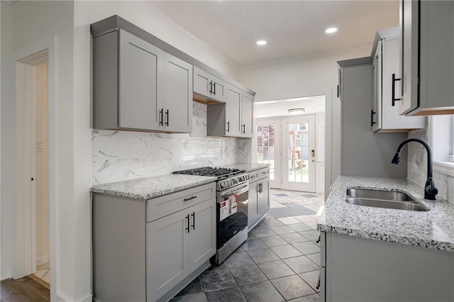 217 N Valley St, Kansas City, KS 66102 - kitchen featuring stainless steel gas range oven, a sink, ornamental molding, decorative backsplash, and light stone countertops