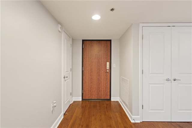 hallway with wood finished floors, baseboards, and recessed lighting