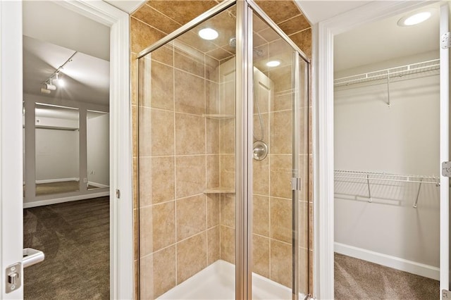 bathroom with a stall shower and a spacious closet