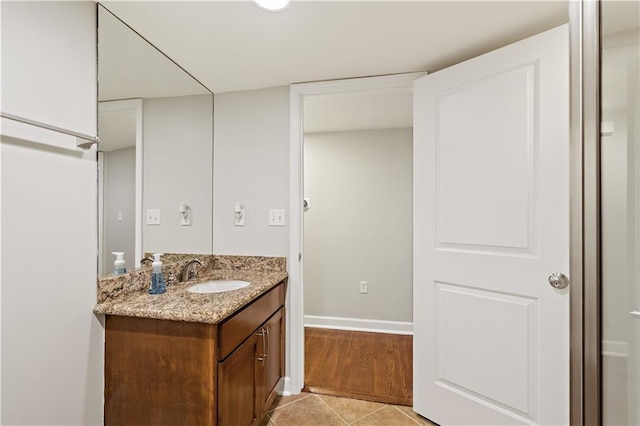 bathroom with vanity, baseboards, and tile patterned flooring