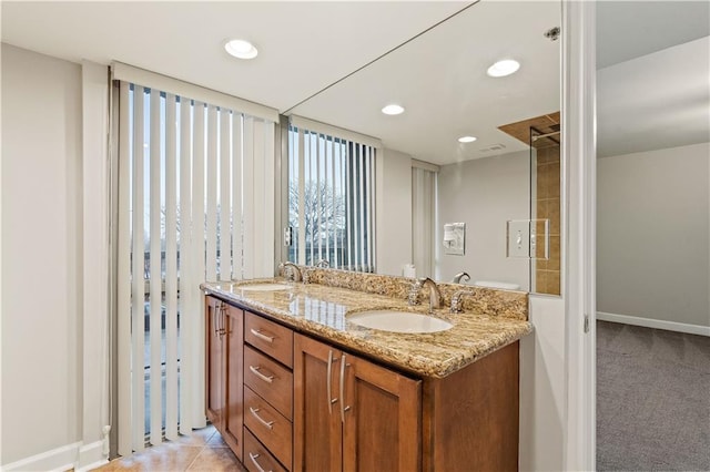 full bath with baseboards, double vanity, and recessed lighting