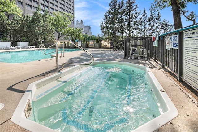 community pool featuring fence and a patio area