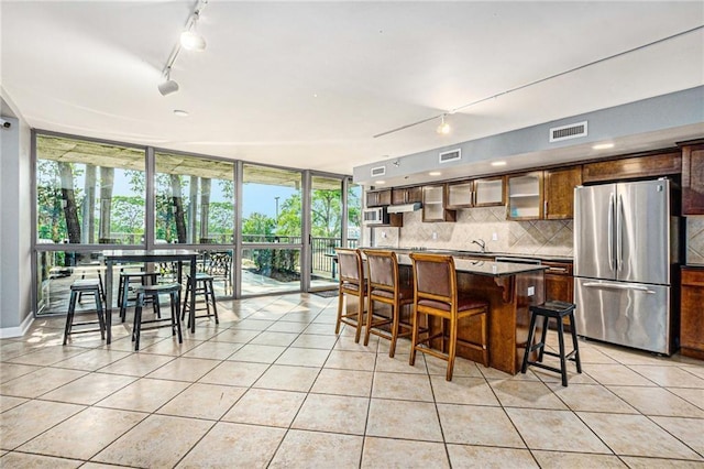 dining space featuring light tile patterned floors, rail lighting, and floor to ceiling windows