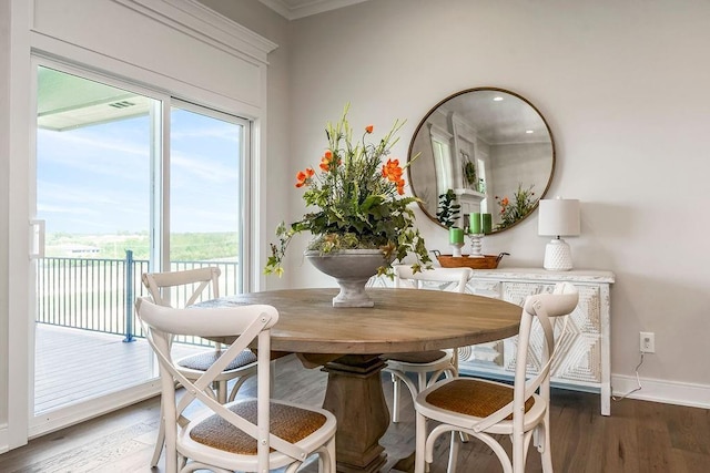 dining space with ornamental molding, baseboards, and wood finished floors