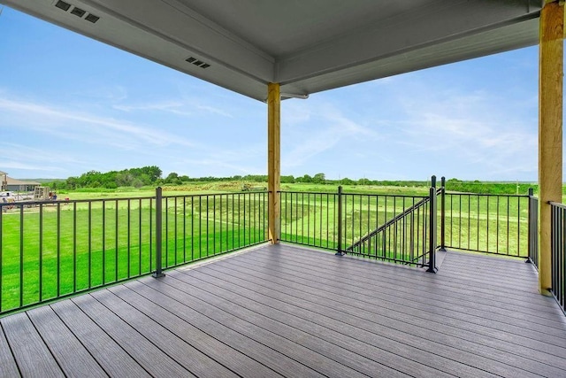deck with a rural view, visible vents, and a lawn