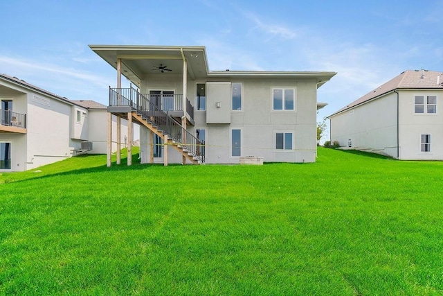rear view of house featuring a lawn, stairway, and ceiling fan