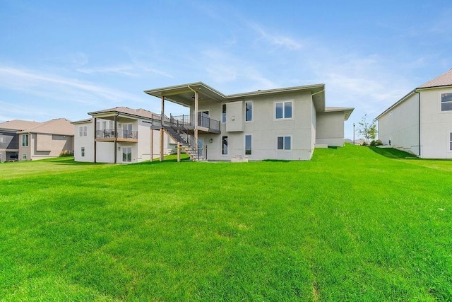 rear view of property with a yard, stucco siding, and stairway