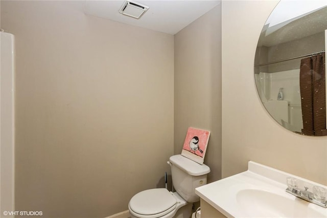 bathroom with toilet, a shower with shower curtain, vanity, and baseboards