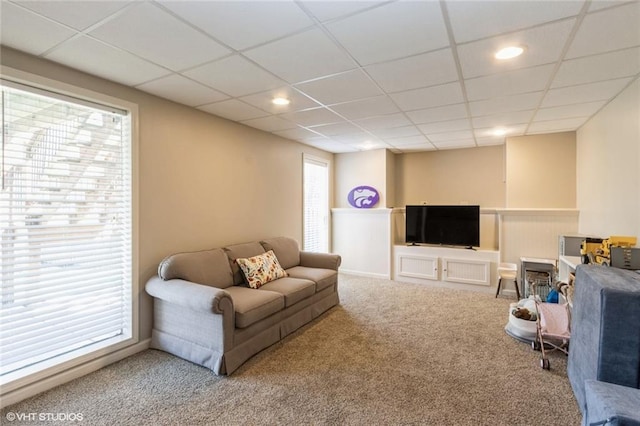 living room featuring carpet, a paneled ceiling, plenty of natural light, recessed lighting, and a wainscoted wall