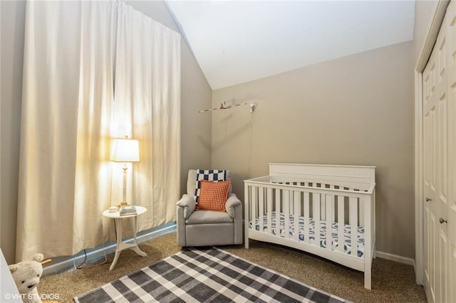 bedroom featuring carpet floors, a closet, lofted ceiling, and a crib