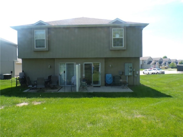 rear view of house with a lawn and a patio