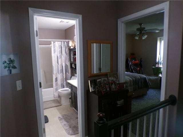 ensuite bathroom with toilet, ensuite bathroom, vanity, shower / bath combo, and a ceiling fan