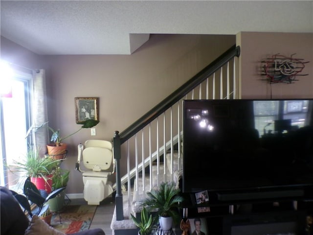 stairs with a textured ceiling and wood finished floors