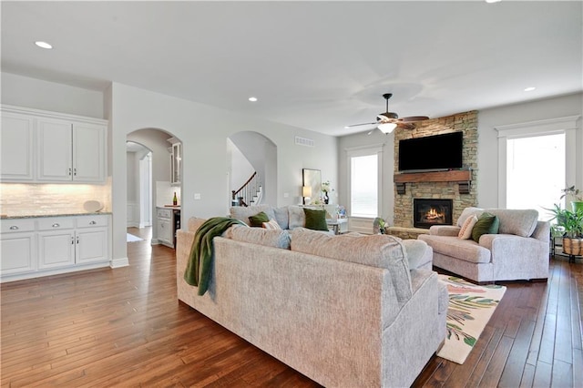 24411 W 70th St, Shawnee, KS 66226 - living room with a fireplace, hardwood / wood-style floors, a ceiling fan, stairs, and arched walkways