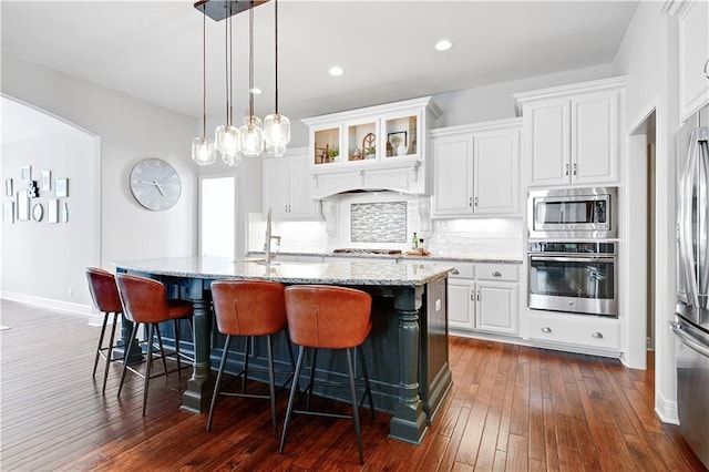 24411 W 70th St, Shawnee, KS 66226 - kitchen featuring appliances with stainless steel finishes, a sink, a breakfast bar, light stone counters, and decorative backsplash
