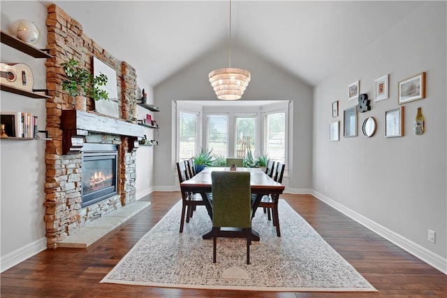 24411 W 70th St, Shawnee, KS 66226 - dining area featuring dark wood-style floors, a fireplace, vaulted ceiling, a chandelier, and baseboards