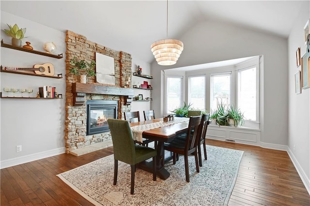 24411 W 70th St, Shawnee, KS 66226 - dining area featuring plenty of natural light, a stone fireplace, vaulted ceiling, hardwood / wood-style flooring, and baseboards
