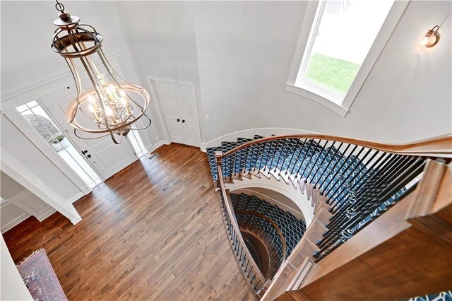 24411 W 70th St, Shawnee, KS 66226 - stairway featuring a chandelier, wood finished floors, and a high ceiling