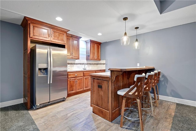 24411 W 70th St, Shawnee, KS 66226 - kitchen with stainless steel refrigerator with ice dispenser, a breakfast bar, a sink, light wood-type flooring, and baseboards