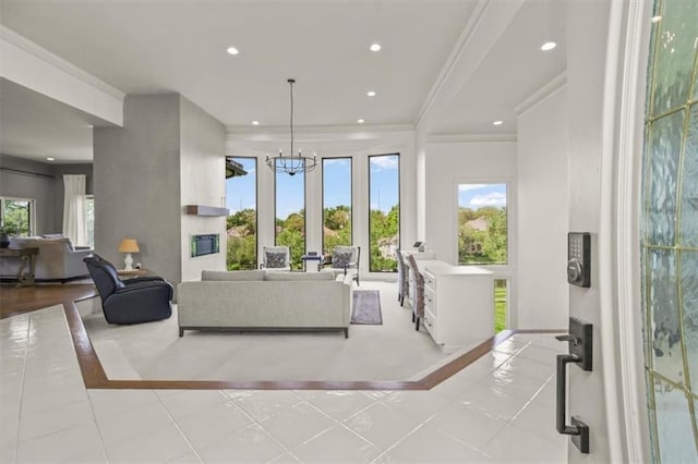 living room featuring inlaid floor details, recessed lighting, ornamental molding, a chandelier, and baseboards