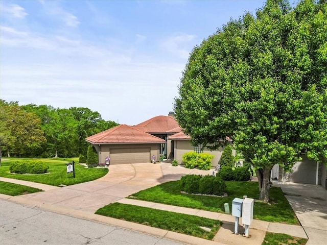 view of front of home featuring concrete driveway, a front lawn, a tile roof, stucco siding, and a garage