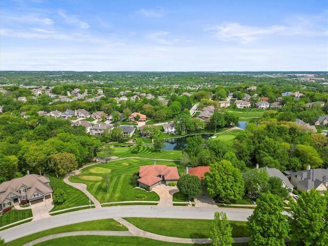 view of property location featuring nearby suburban area, a nearby body of water, a golf club, and a tree filled landscape