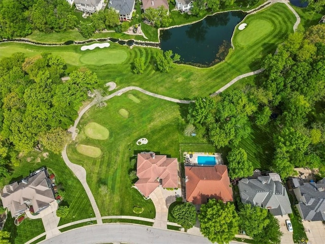 aerial view of property's location with a nearby body of water, nearby suburban area, and a golf club