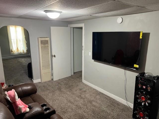 carpeted living area with arched walkways and baseboards