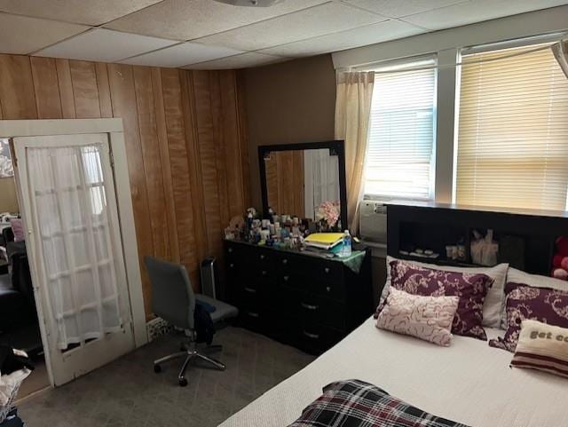 carpeted bedroom featuring wooden walls
