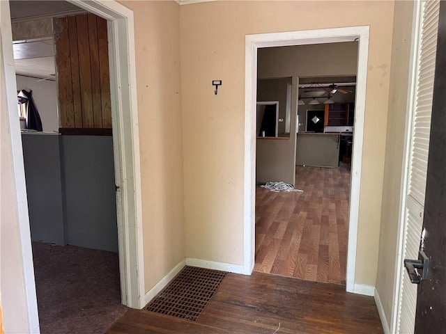 corridor featuring baseboards and wood finished floors