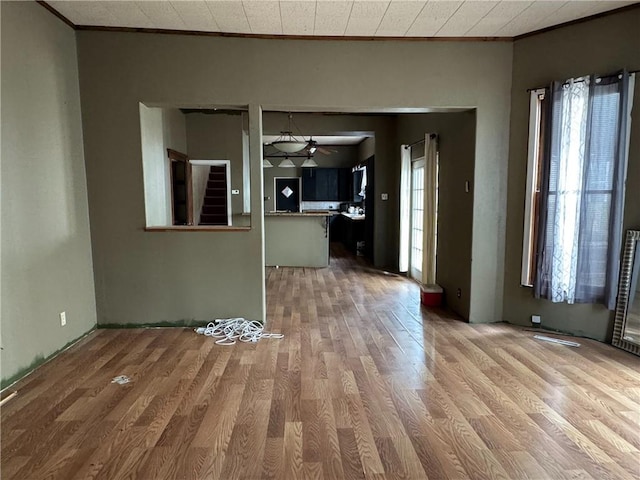 interior space with crown molding, wood finished floors, and a ceiling fan