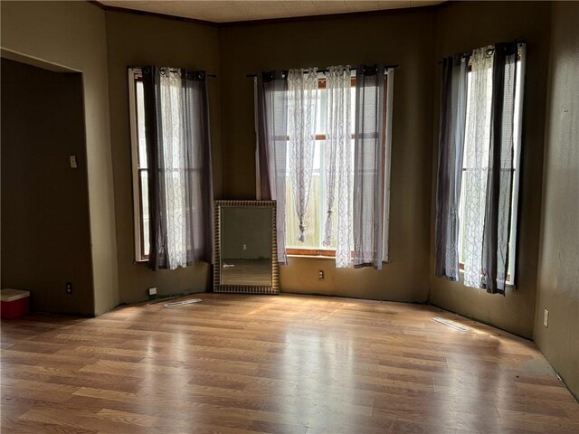 empty room featuring visible vents and wood finished floors