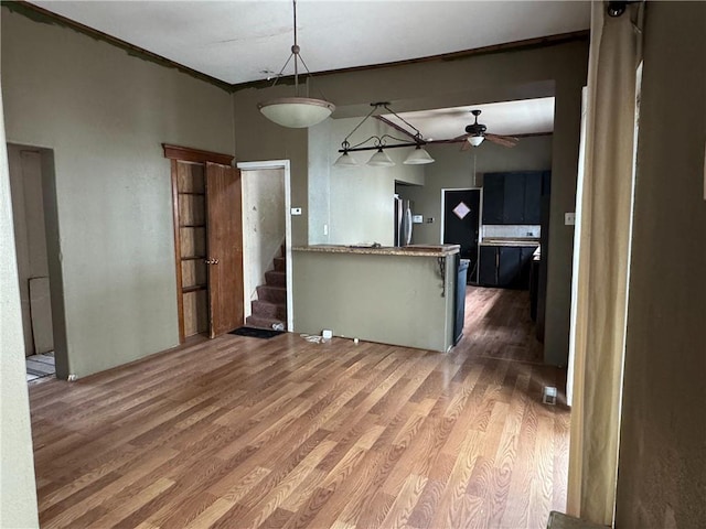 interior space with stairs, crown molding, ceiling fan, and wood finished floors
