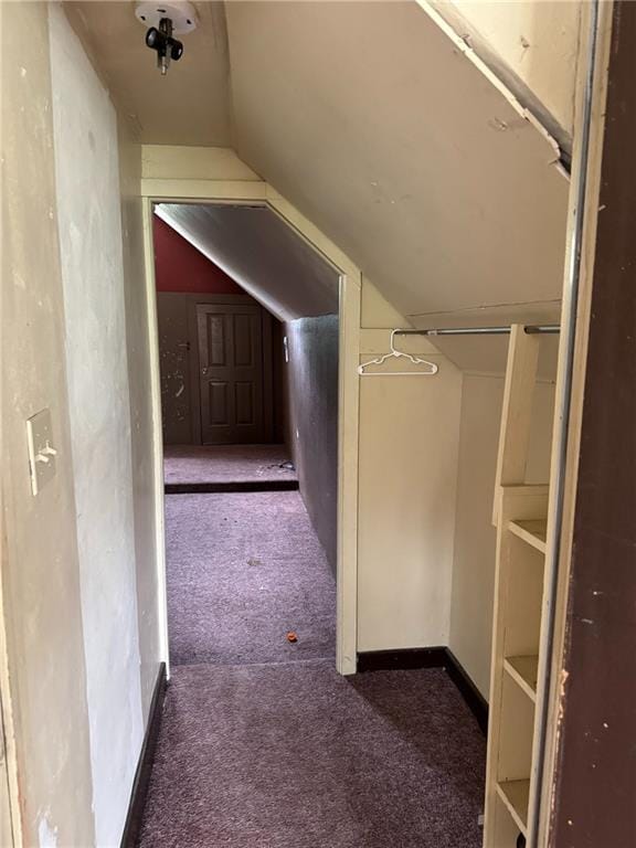 hallway with carpet flooring and vaulted ceiling