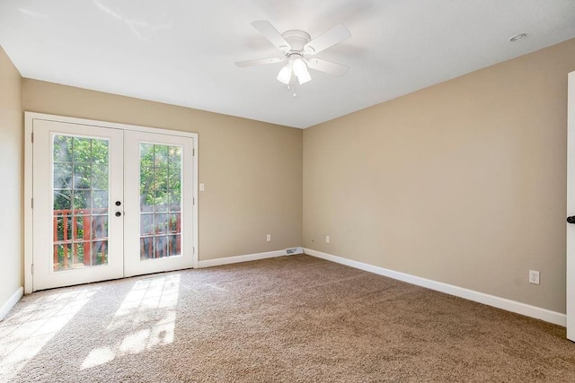 carpeted spare room featuring french doors, baseboards, and a ceiling fan