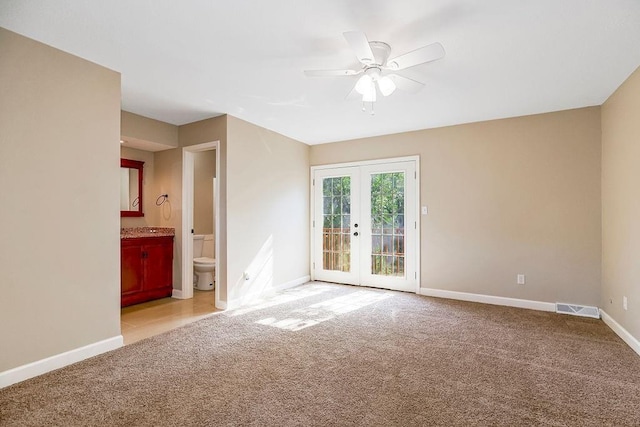 carpeted empty room featuring french doors, ceiling fan, and baseboards