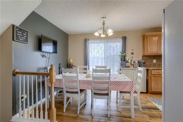 8403 NE 115th Ter, Kansas City, MO 64157 - dining space with a chandelier, light wood-type flooring, and a textured ceiling