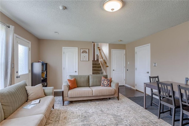 8403 NE 115th Ter, Kansas City, MO 64157 - living area with a textured ceiling, stairway, baseboards, and dark wood-type flooring