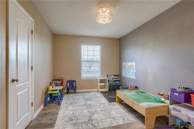 8403 NE 115th Ter, Kansas City, MO 64157 - recreation room with wood finished floors, a textured ceiling, and baseboards