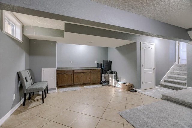 8403 NE 115th Ter, Kansas City, MO 64157 - basement with a textured ceiling, light tile patterned floors, stairway, and baseboards