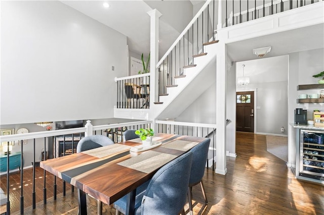 9808 N Hedges Ave, Kansas City, MO 64157 - dining room with wood finished floors, beverage cooler, stairs, baseboards, and a high ceiling