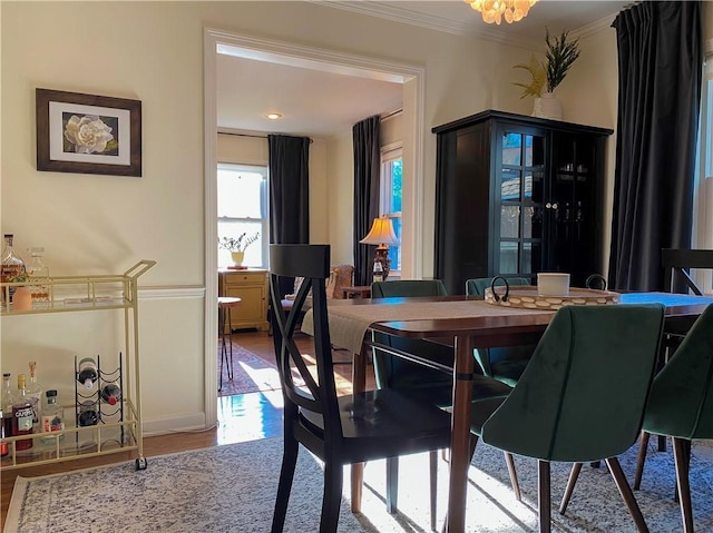 dining room with ornamental molding, wood finished floors, and a chandelier
