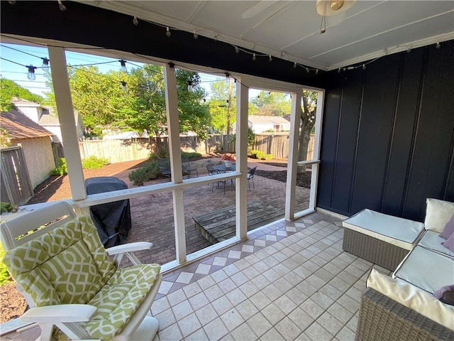 unfurnished sunroom with rail lighting and ceiling fan
