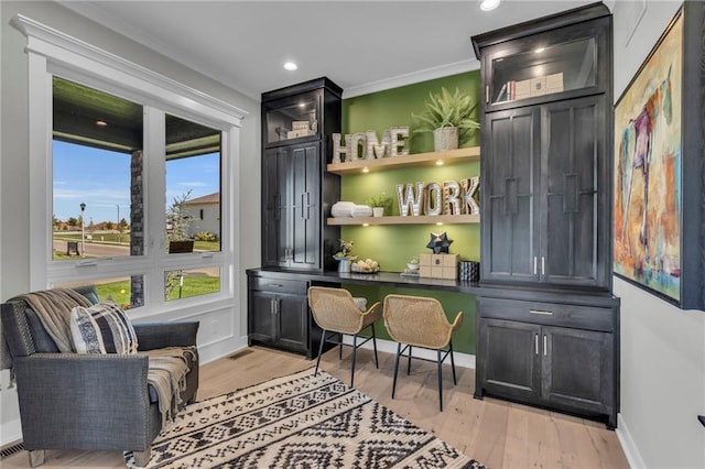 interior space featuring light wood-style flooring, baseboards, and ornamental molding