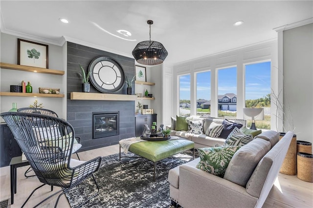 living room with recessed lighting, a tile fireplace, crown molding, and wood finished floors