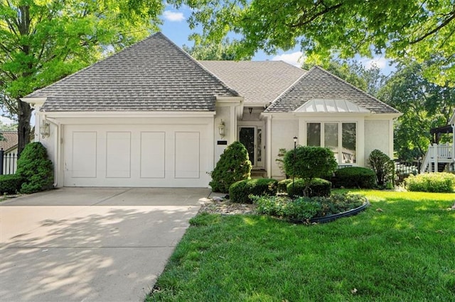 7955 W 118th Pl, Overland Park, KS 66210 - view of front of house featuring roof with shingles, an attached garage, concrete driveway, a front lawn, and stucco siding