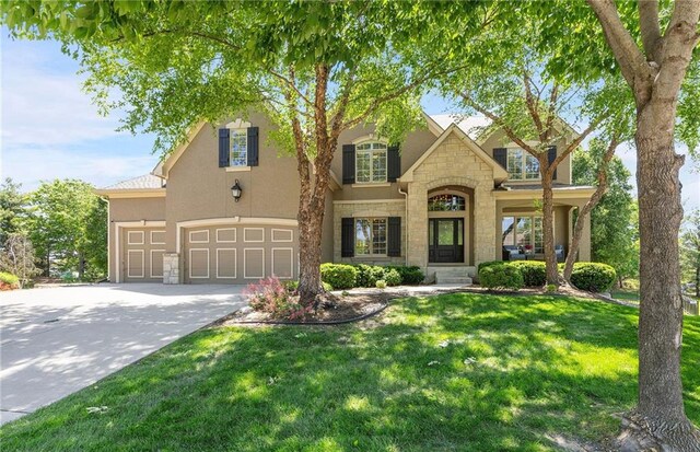 8701 W 157th St, Overland Park, KS 66221 - traditional-style home featuring stone siding, an attached garage, concrete driveway, a front yard, and stucco siding