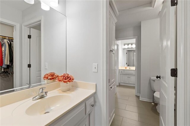 8701 W 157th St, Overland Park, KS 66221 - bathroom featuring toilet, vanity, a walk in closet, and tile patterned flooring